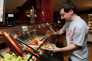 A customer uses the Hilltop salad bar